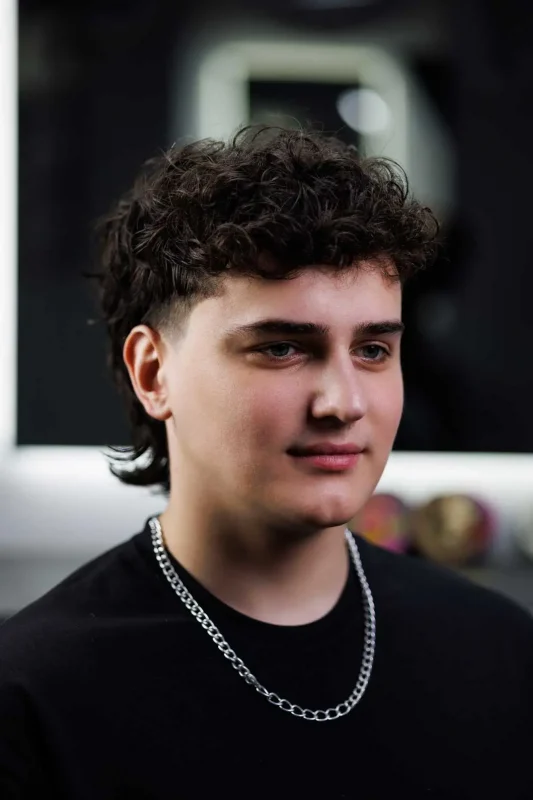 Мужская укладка mullet с использованием средств для волос — современный стиль с текстурированным верхом.